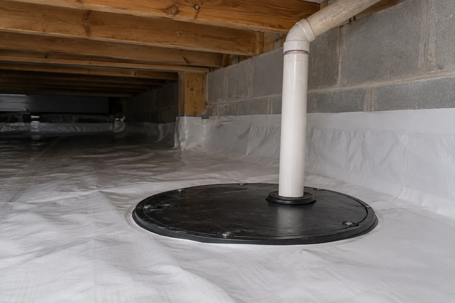 A covered crawlspace sump basin and discharge pipe